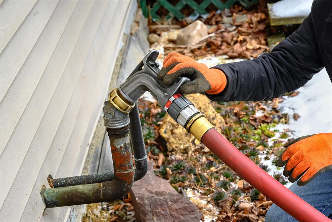 Heating oil delivery driver locking a fill nozzle into a home oil tank in Patchogue, NY